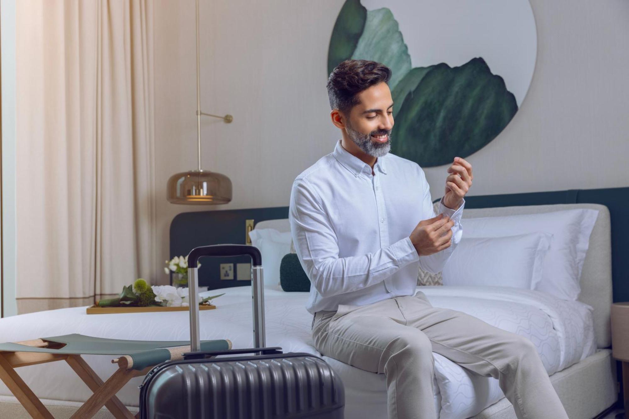 Onyx Rotana Hotel Manama Exterior foto A man using a mobile phone